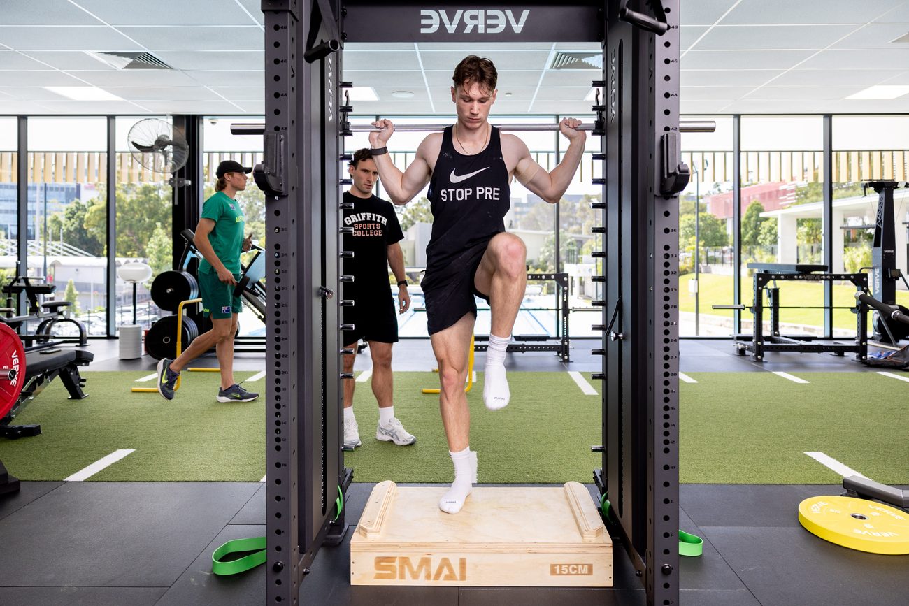 Griffith athletes by the floor-to-ceiling glazing over the campus.